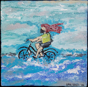 Masked Red Headed Woman Pedaling a Bike on Beach by Mark San Souci